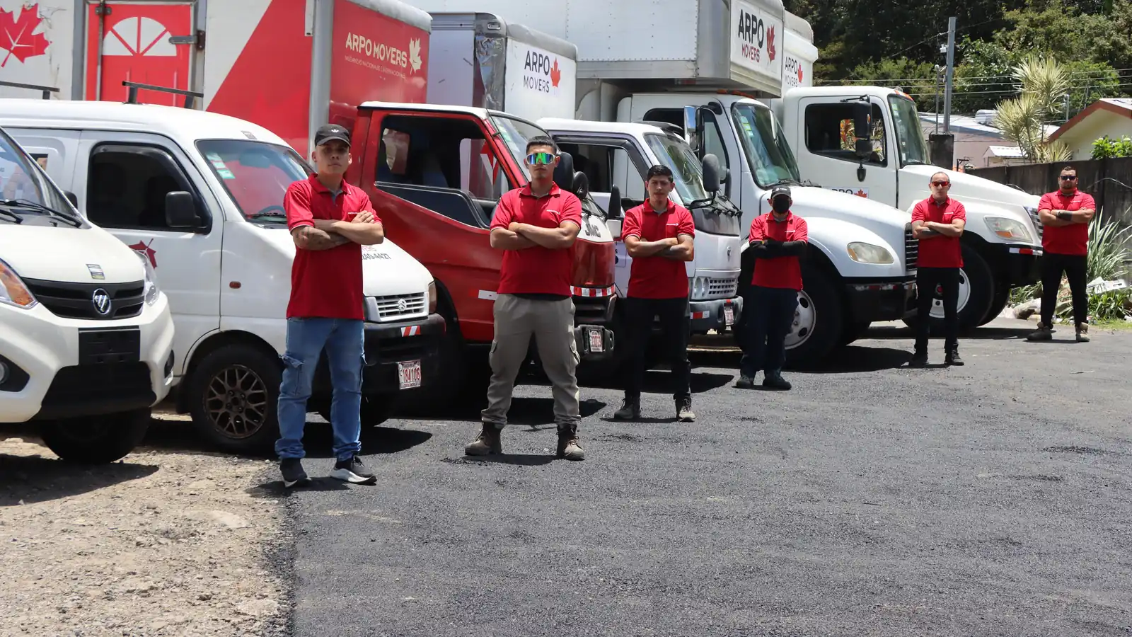 Equipo de Arpo Movers frente a la flota de camiones de mudanza